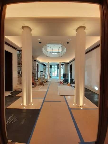 Interior view of a building under renovation, featuring columns and a skylight.